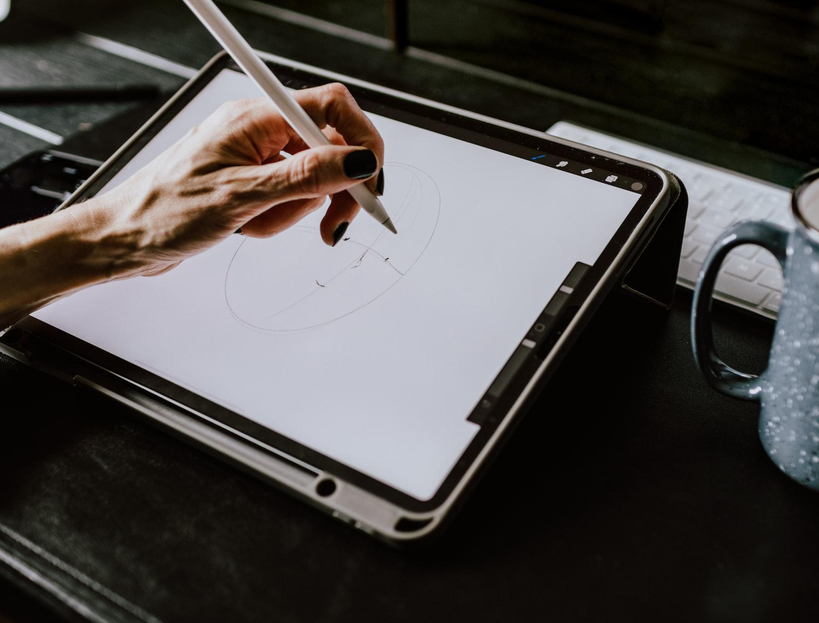 person holding white ipad with black case